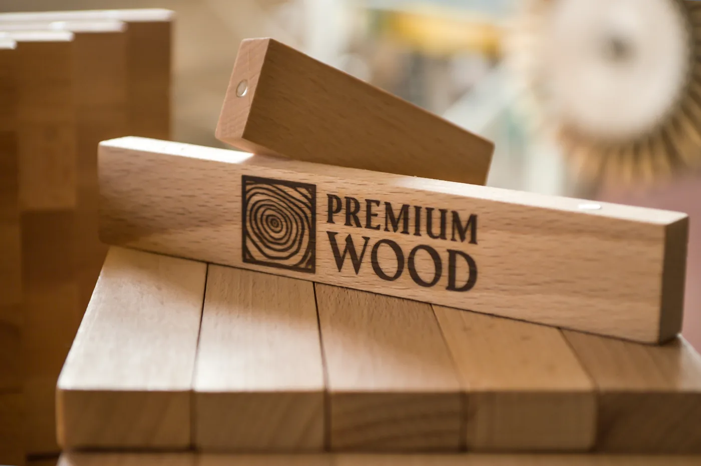 Wypalone logo Premium Wood na drewnianym klocku